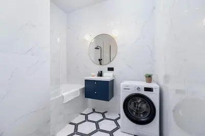 a bathroom with a washing machine and a mirror at Old Town Długa 48 Family Apartment by Noclegi Renters in Kraków