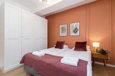 a bedroom with a large bed with orange walls at Old Town Długa 48 Family Apartment by Noclegi Renters in Kraków