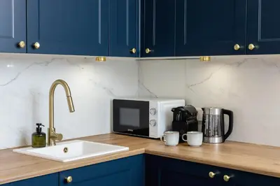 a kitchen counter with a sink and a microwave at Old Town Długa 48 Family Apartment by Noclegi Renters in Kraków