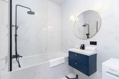 a bathroom with a tub and a sink and a mirror at Old Town Długa 48 Family Apartment by Noclegi Renters in Kraków