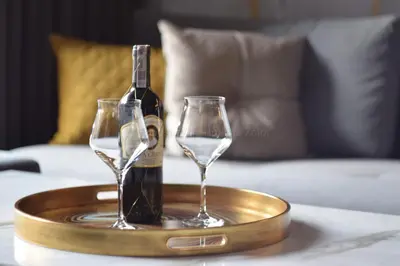 a bottle of wine and two glasses on a tray on a table at EXCLUSIVE APARTMENTS ZATOR in Zator