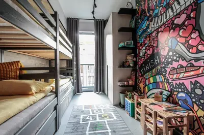 a room with a bed and a wall with graffiti at EXCLUSIVE APARTMENTS ZATOR in Zator