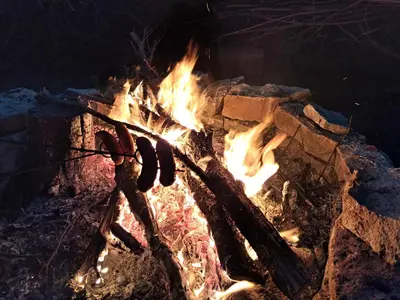 a fire pit with two hot dogs on it at Brzozowy Zakątek in Bochnia