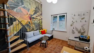 a living room with a couch and a staircase at Brzozowy Zakątek in Bochnia