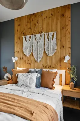 a bedroom with a bed with a wooden wall at Vermelo Boho Apartment in Kraków
