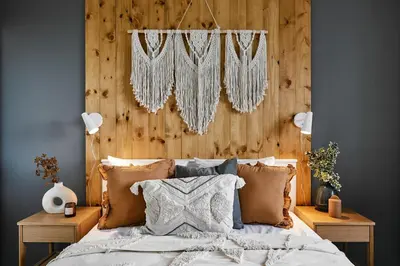 a bedroom with a bed with a wooden headboard at Vermelo Boho Apartment in Kraków