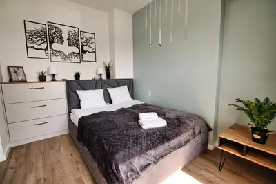 a bedroom with a large bed and a dresser at Just 5 by Housine in Zator