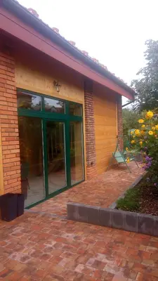 a brick building with a green door on a brick patio at Cztery Pory Roku pokoje z łazienkami do wynajęcia in Osiek