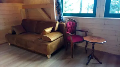 a living room with a couch and a table and a chair at Cztery Pory Roku pokoje z łazienkami do wynajęcia in Osiek