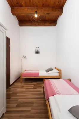 a bedroom with two beds and a wooden ceiling at City of the Kings-Camomile Apartment in Kraków