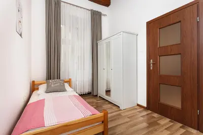 a bedroom with a bed and a wooden door at City of the Kings-Camomile Apartment in Kraków