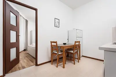 a dining room with a table and chairs and a mirror at City of the Kings-Camomile Apartment in Kraków