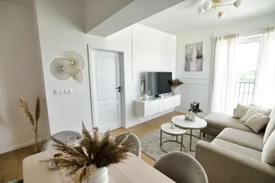 a white living room with a couch and a table at Azyl by Housine in Zator