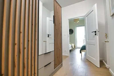 a hallway with white walls and a large mirror at Azyl by Housine in Zator