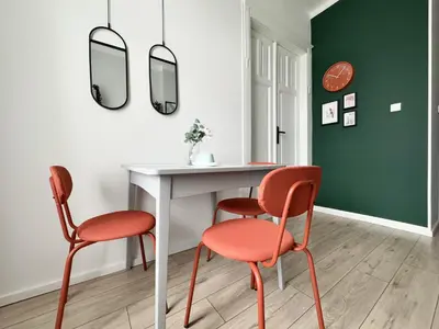 a dining room with two chairs and a table with two mirrors at GREEN APARTMENTS #Kazimierz, building A in Kraków