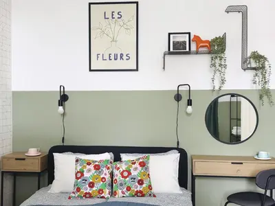 a bedroom with a bed with two pillows and a mirror at GREEN APARTMENTS #Kazimierz, building A in Kraków