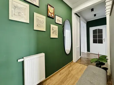 a hallway with a green wall with a radiator at GREEN APARTMENTS #Kazimierz, building A in Kraków