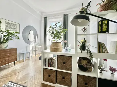 a living room with a book shelf with books at GREEN APARTMENTS #Kazimierz, building A in Kraków
