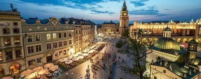 a view of a city with a clock tower at night at Apartament Berka 9 in Kraków