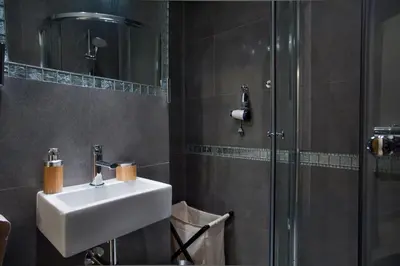 a bathroom with a sink and a shower at Apartament Berka 9 in Kraków