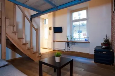 a living room with a staircase and a table at Apartament Berka 9 in Kraków