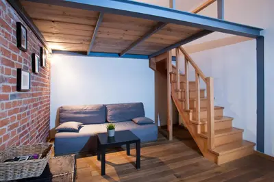 a living room with a couch and a staircase at Apartament Berka 9 in Kraków