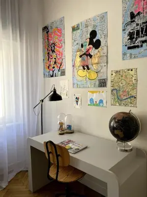 a desk with a chair and some pictures on the wall at In the heart of old town in Kraków