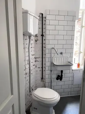 a white bathroom with a toilet and a sink at In the heart of old town in Kraków