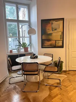 a dining room with a white table and chairs at In the heart of old town in Kraków