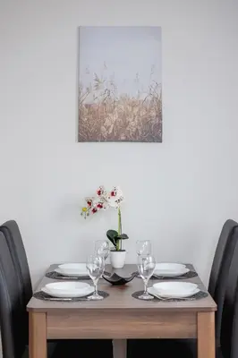 a dining room table with plates and wine glasses at Cozy Apartment with Balcony Chmieleniec by Noclegi Renters in Kraków