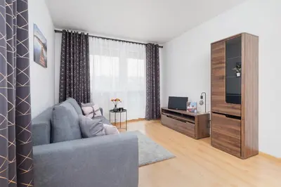 a living room with a couch and a television at Cozy Apartment with Balcony Chmieleniec by Noclegi Renters in Kraków