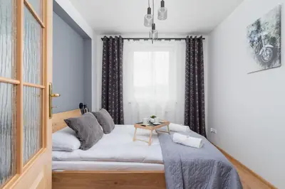 a small room with a bed and a window at Cozy Apartment with Balcony Chmieleniec by Noclegi Renters in Kraków