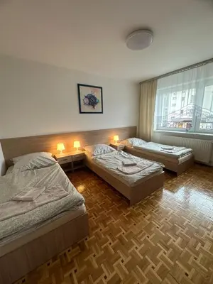 a bedroom with two beds and a couch and a window at Apartament Jaśminowa in Chrzanów