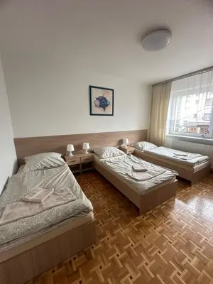 a bedroom with two beds and a window at Apartament Jaśminowa in Chrzanów