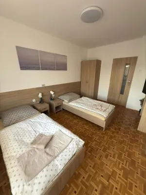 two beds in a room with wooden floors at Apartament Jaśminowa in Chrzanów