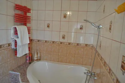 a bathroom with a tub and a shower with towels at Flamingo in Poręba Żegoty