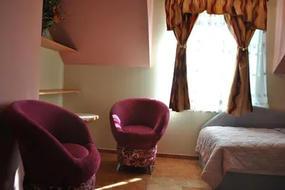 a room with two chairs and a bed and a window at Flamingo in Poręba Żegoty