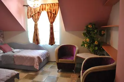 a bedroom with a bed and a chair and a window at Flamingo in Poręba Żegoty