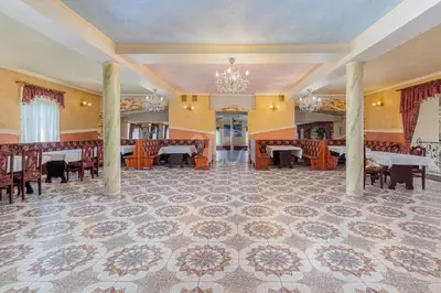 a dining room with tables and chairs and a chandelier at Flamingo in Poręba Żegoty