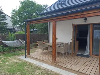 a patio with a table and chairs on a deck at Piękne Zielone in Zator