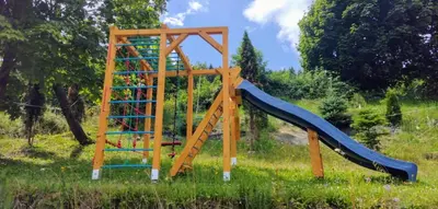 a playground with a slide in the grass at Domek Na Przełęczy in Wierzbanowa