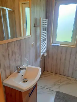 a bathroom with a sink and a window at Domek Na Przełęczy in Wierzbanowa