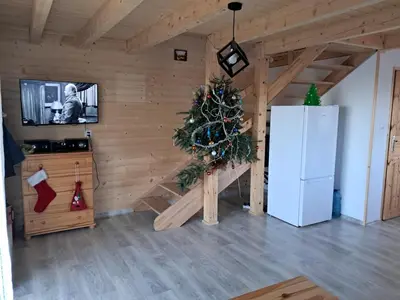 a living room with a christmas tree and a tv at Domek Na Przełęczy in Wierzbanowa