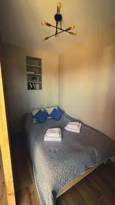 a bedroom with a bed with blue sheets and blue pillows at Karmelowy Apartment in Zator
