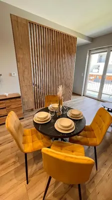 a dining room with a table and yellow chairs at Karmelowy Apartment in Zator
