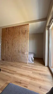 a bedroom with a bed and a wooden floor at Karmelowy Apartment in Zator