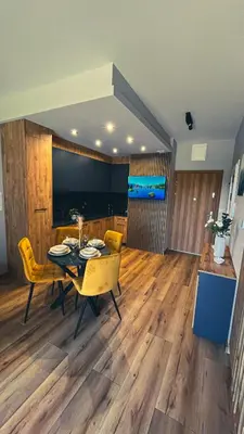 a dining room with a table and yellow chairs at Karmelowy Apartment in Zator