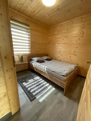 a room with a bed in a wooden cabin at Brzozowy Zakątek Zator in Zator