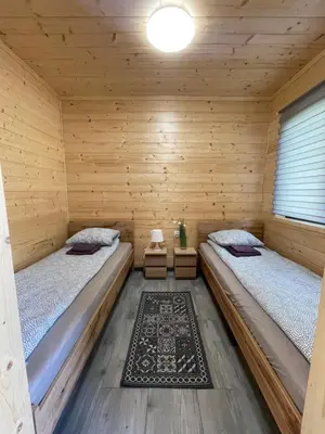 a room with two beds in a wooden cabin at Brzozowy Zakątek Zator in Zator