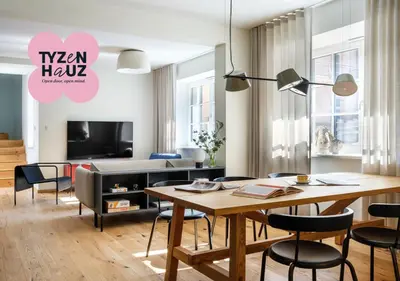 a living room with a table and chairs and a tv at Tyzenhauz Villas in Kraków
